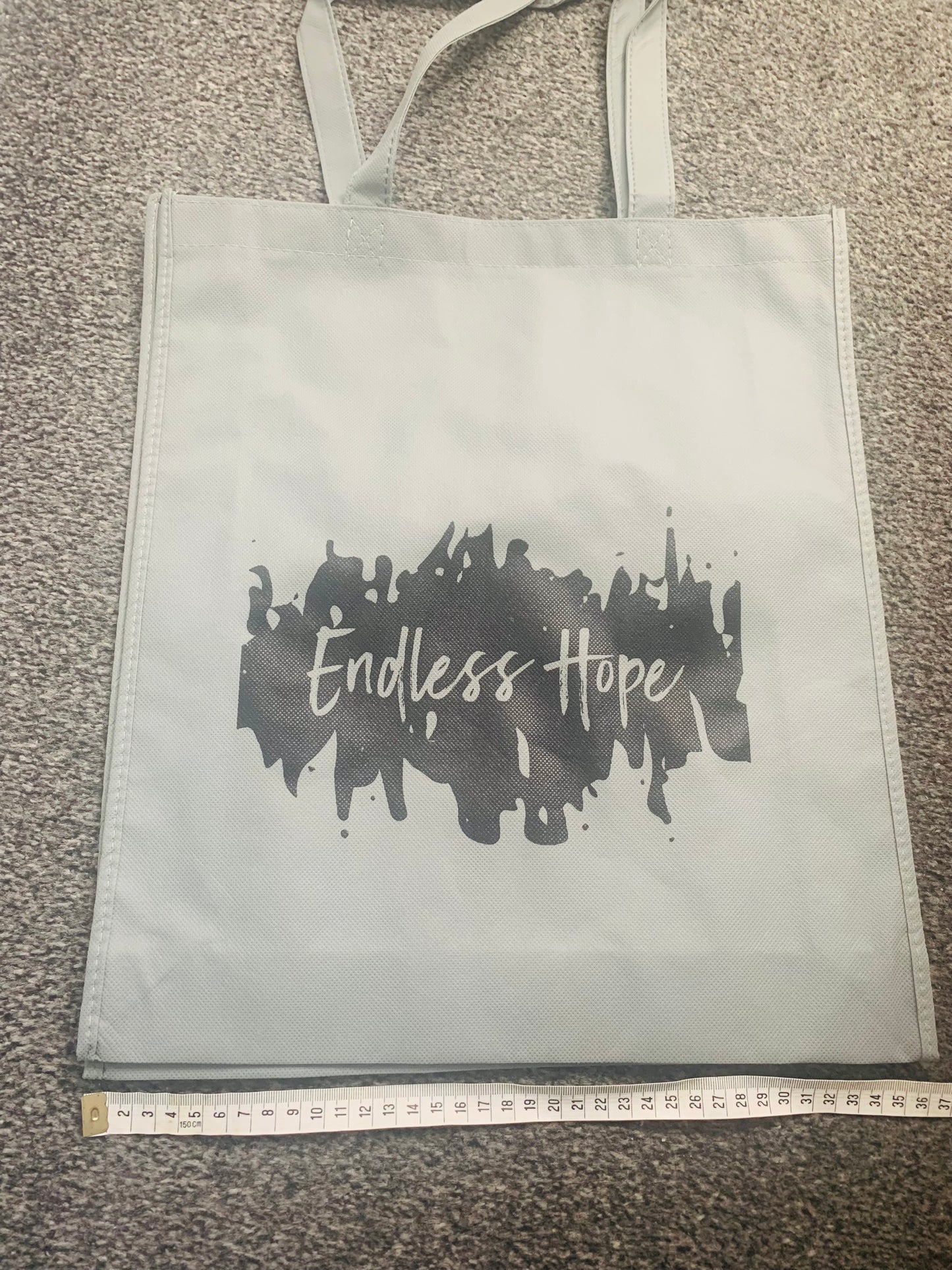 Eco friendly grey bag with black endless hope design on the front.
